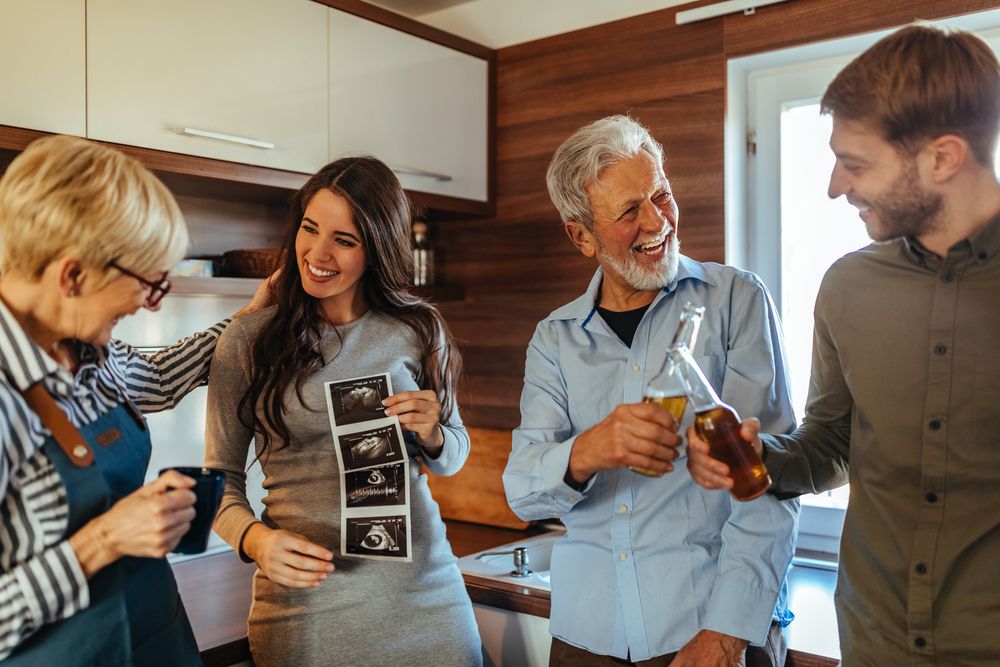 Coppia che condivide con i familiari la notizia del percorso di procreazione medicalmente assistita in un momento di confronto sereno