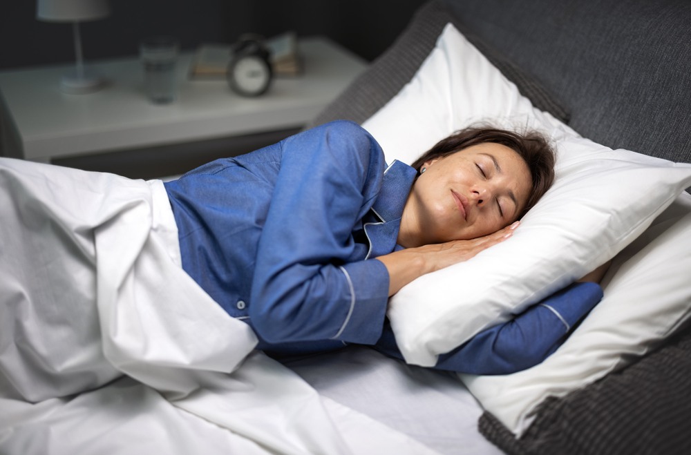Donna che dorme serenamente durante un percorso di fecondazione assistita, con luce soffusa notturna